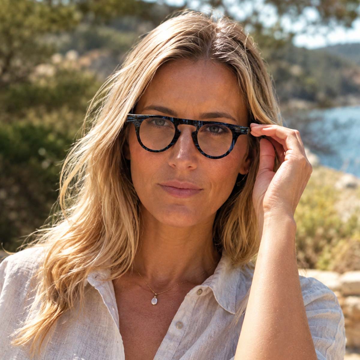 Lunettes de lecture unisexes à monture ronde, motif graphique bleu et noir.
Unisex reading glasses with a round frame featuring a blue and black graphic pattern.