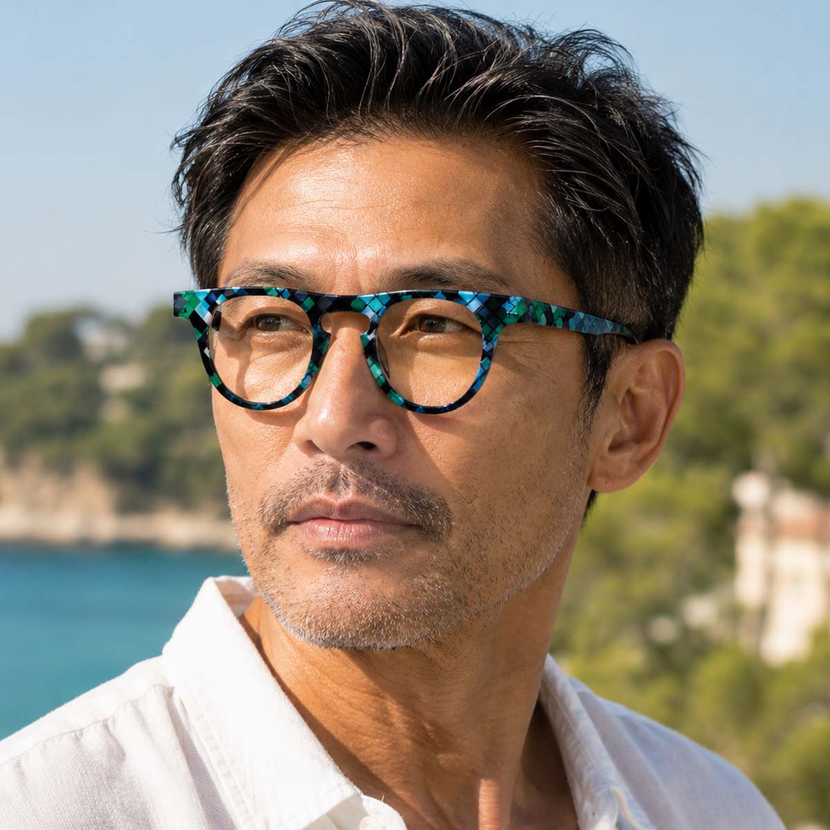 Lunettes de lecture unisexes à monture ronde, motif graphique bleu turquoise, vert et noir.
Unisex reading glasses with a round frame featuring a turquoise blue, green and black graphic pattern.